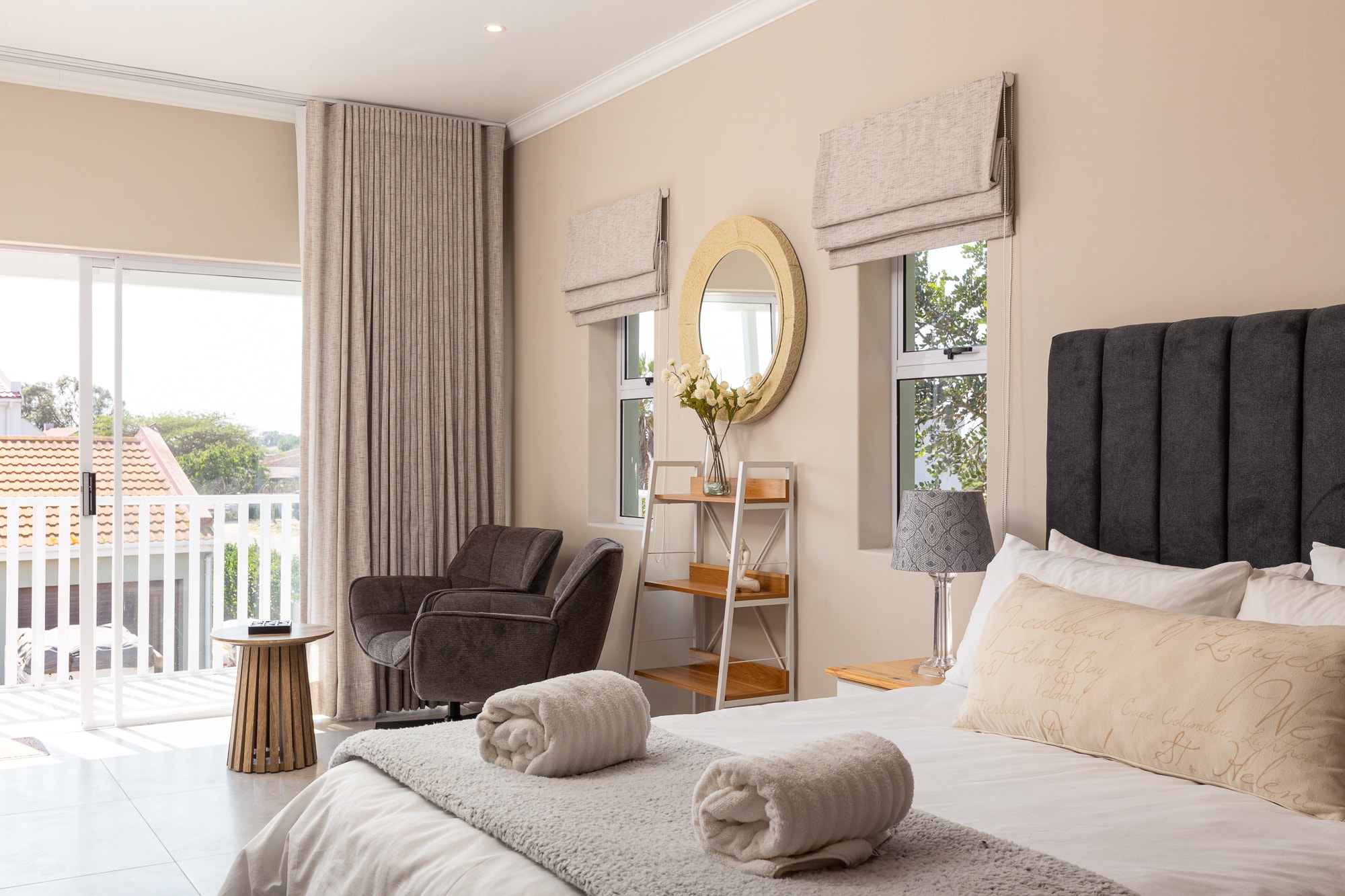 Modern bedroom with gold mirror and balcony
