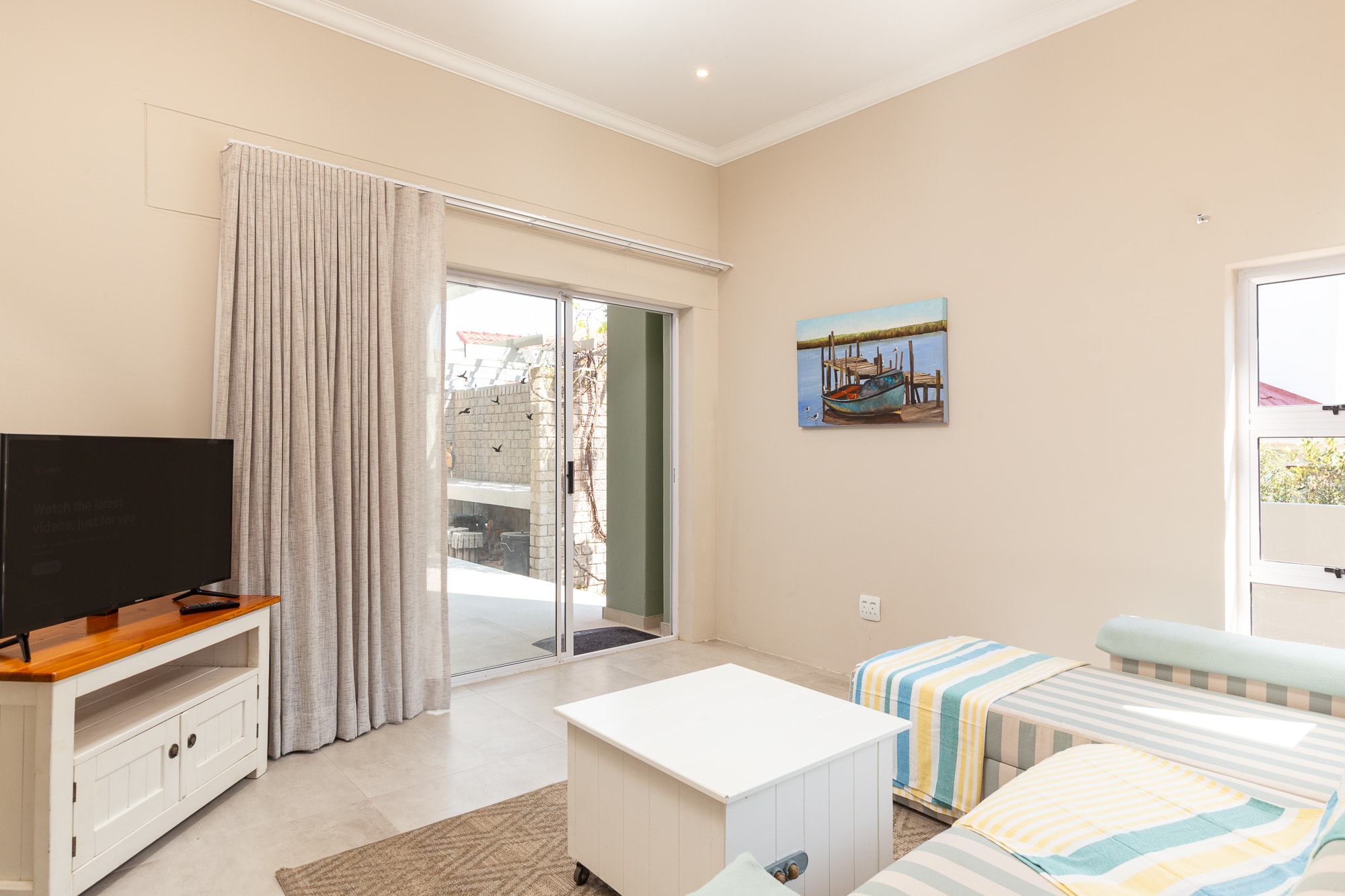 Modern bedroom with coastal decor and balcony