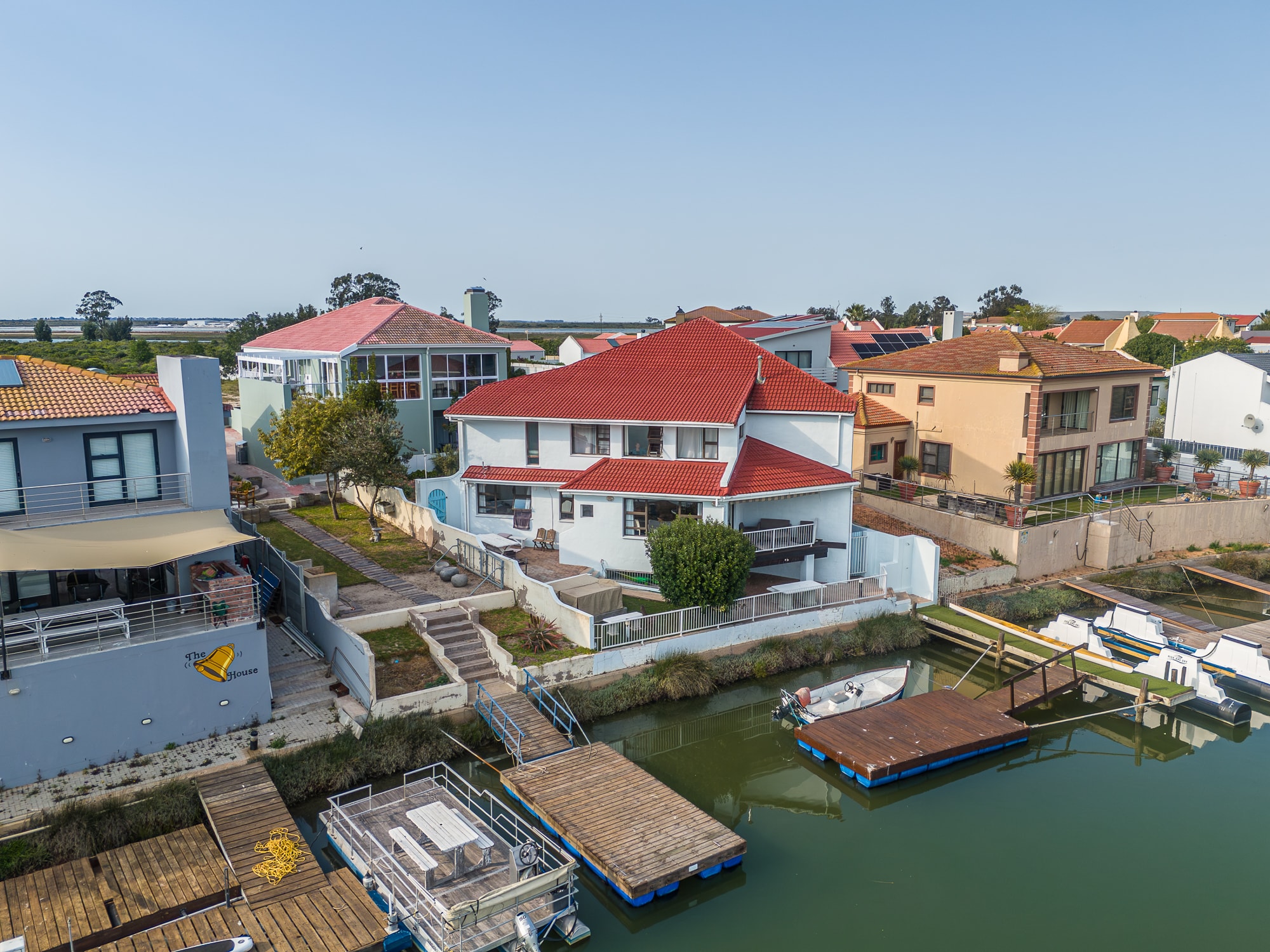 Waterfront homes with red tile roofs and canal